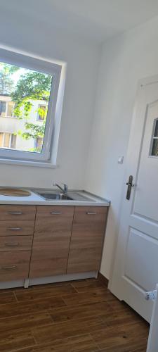 a bathroom with a sink and a window at "Hel" Wieniec Zdrój in Włocławek
