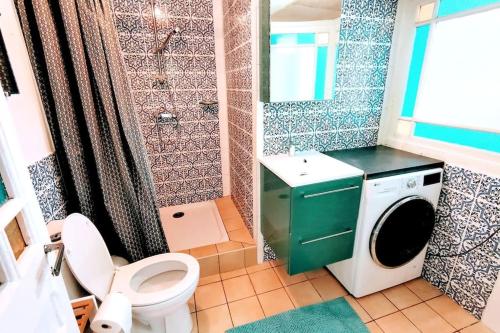 Un baño con inodoro y lavadora. en Maison de charme à 200 bord de mer, terrasse, jardin- Lesclesdenicole, en Le Pradet