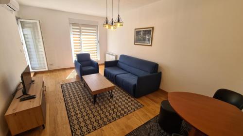 a living room with a blue couch and a table at Porta di Zemun in Novi Grad
