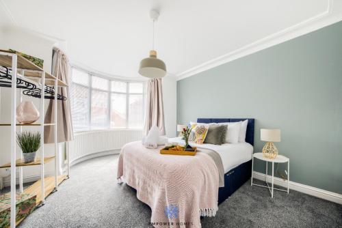 um quarto com uma cama com um cobertor rosa em Coventry Large Stylish 4 Bedroom House, Sleeps 8, Private Parking, by EMPOWER HOMES em Coventry