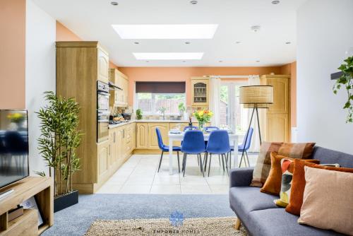 a living room with a couch and a table and chairs at Coventry Large Stylish 4 Bedroom House, Sleeps 8, Private Parking, by EMPOWER HOMES in Coventry