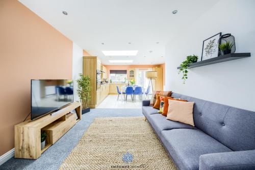 a living room with a blue couch and a tv at Coventry Large Stylish 4 Bedroom House, Sleeps 8, Private Parking, by EMPOWER HOMES in Coventry