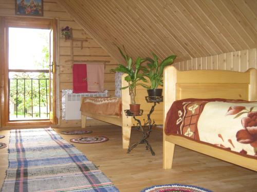 ein Schlafzimmer mit einem Bett in einem Holzhaus in der Unterkunft Saduba Kozatska Detsa in Schdenijewo