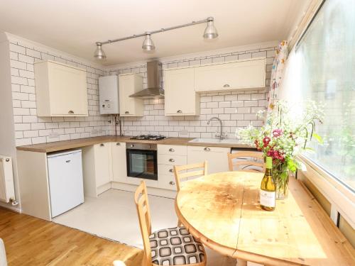 a kitchen with a wooden table with flowers on it at Willow Cabin in Cowes
