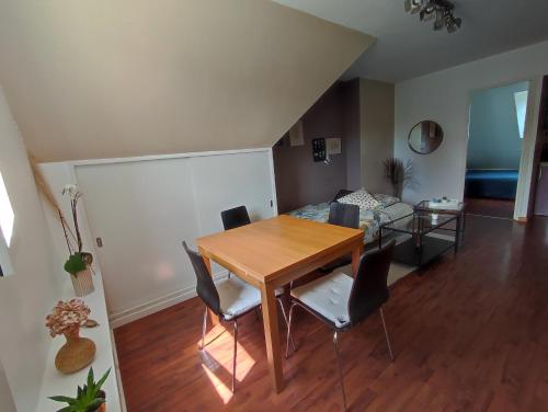 a living room with a table and chairs and a bed at Appartement calme aux portes de Rennes in Vezin-le-Coquet