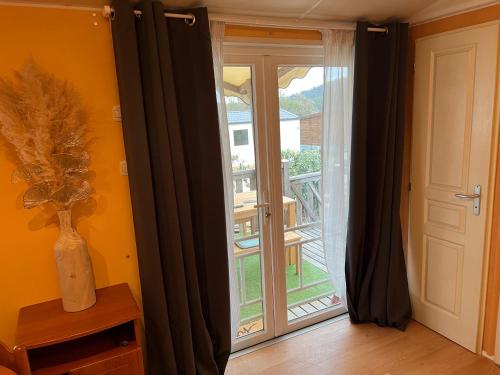 a room with a sliding glass door with a balcony at Joli Mobil-Home de Vacances, Ideal pour les familles in Rocbaron