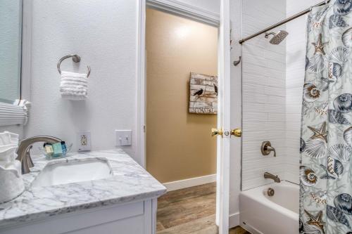 a white bathroom with a sink and a shower at Crows Coastal Cottage in Waldport