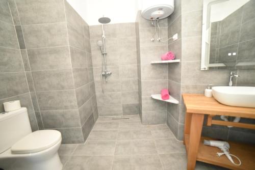 a bathroom with a toilet and a sink and a shower at Beachfront Marilyn in Durrës