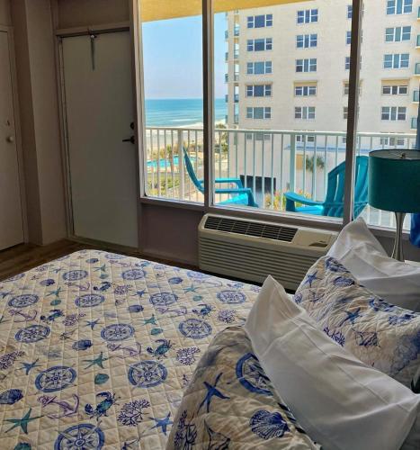 a bedroom with a bed with a view of the ocean at Castaways Resort Studios in Daytona Beach
