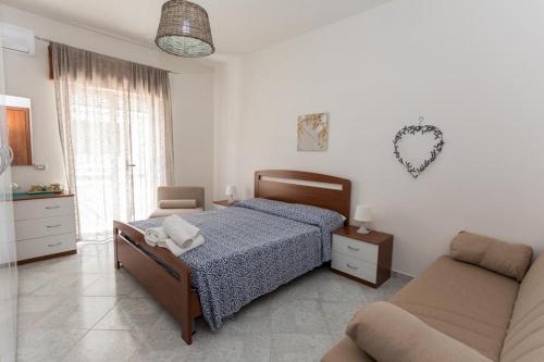 1 dormitorio con 1 cama y 1 sofá en B&B La Barcaccia en Tortora