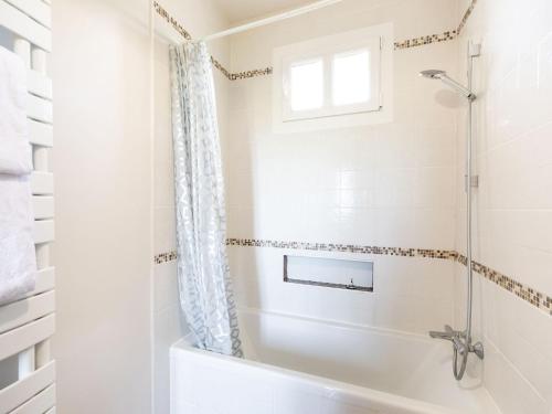 a bathroom with a tub and a shower with a window at Elegant Château Escape in Cézac