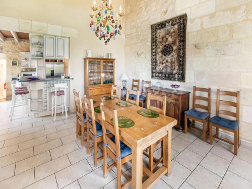 a kitchen and dining room with a wooden table and chairs at Elegant Château Escape in Cézac