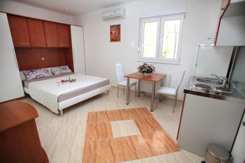 1 dormitorio con cama, mesa y cocina en Apartments Villa Dalmazia, en Trogir
