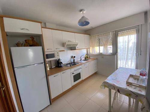 a kitchen with white cabinets and a white refrigerator at -. Villa Nena .- in Ledesma