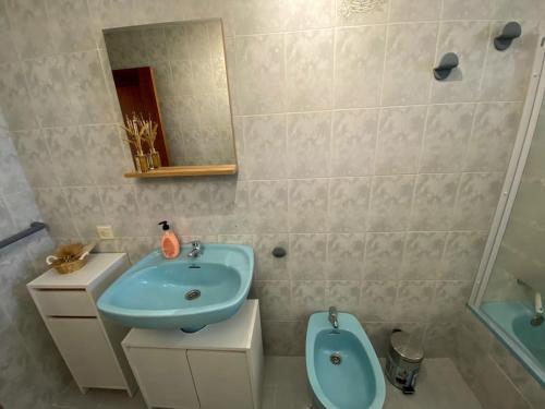 a bathroom with a blue sink and a toilet at -. Villa Nena .- in Ledesma