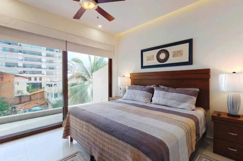a bedroom with a bed and a large window at Nayri Life 509 in Puerto Vallarta