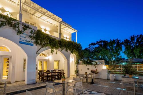 un patio con tavoli e sedie di fronte a un edificio di Hotel Eucalyptus a Mesariá