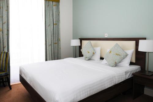 a bedroom with a bed with white sheets and pillows at Hyde Park Boutique Hotel in London