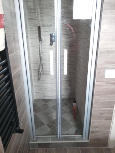 W łazience znajduje się prysznic ze szklanymi drzwiami. w obiekcie Stella alpina w mieście Sappada