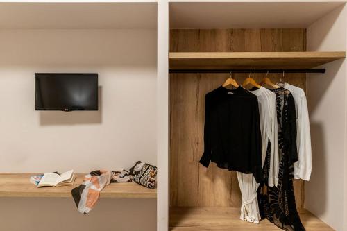 a walk in closet with a television and clothes at Hotel Eucalyptus in Mesaria