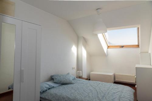 a small bedroom with a bed and a window at Habitaciòn independiente con cama doble en dúplex in A Coruña