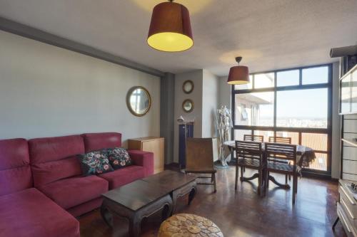 a living room with a red couch and a table at Habitaciòn independiente con cama doble en dúplex in A Coruña