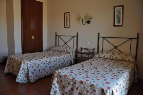 two beds in a hotel room with at Hotel Alonso de Monroy in Belvis de Monroy