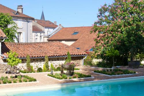 a swimming pool in a yard with a garden at La Pêche in Piégut-Pluviers