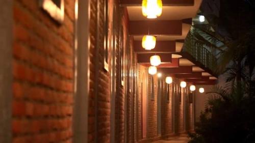 eine Reihe von Leuchten an der Seite eines Backsteingebäudes in der Unterkunft Hôtel Saint Jean Leopold in Kigali