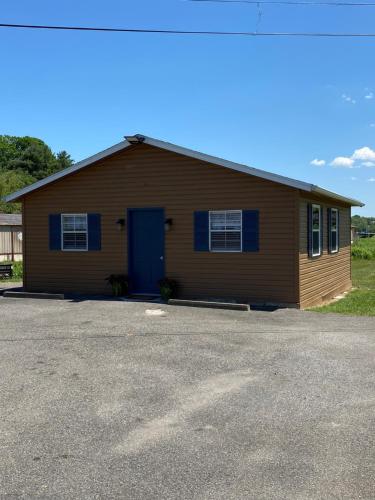 ein braunes Gebäude mit blauer Tür auf einem Parkplatz in der Unterkunft Andy Griffith Parkway Inn in Mount Airy