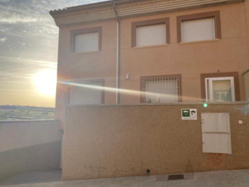 a building with the sun setting behind it at Casa Rural La Sureña in Ossa de Montiel