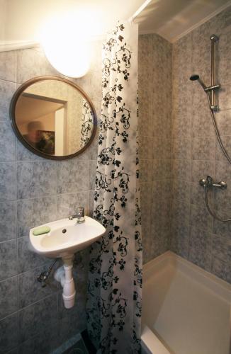 a bathroom with a sink and a shower with a mirror at House & Garden by the beach in Orebić