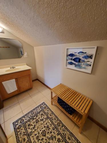 a bathroom with a sink and a wooden bench at Treehouse Condos - Branson in Branson