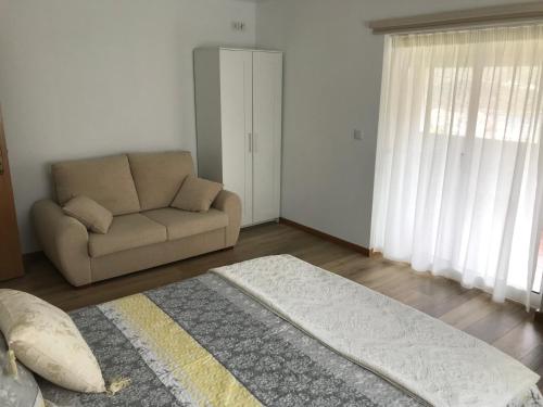 a living room with a couch and a chair at Casa José Lourenço in Folgosa
