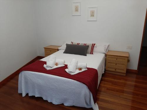 Un dormitorio con una cama blanca con toallas. en Pensión A Fonte, en Caldas de Reis