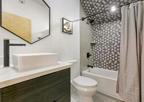a bathroom with a sink and a toilet and a tub at Ivory 2 Bedroom Villa in New Orleans