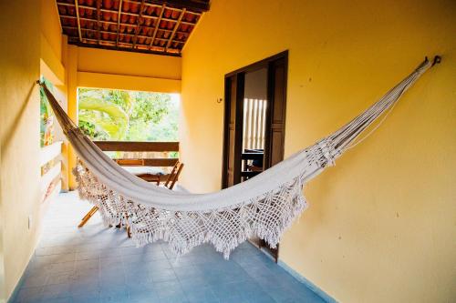a hammock hanging from a wall in a room at Pousada Village Porto Mirim por Carpediem in Jacumã