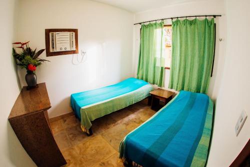 a room with two beds and a window at Pousada Village Porto Mirim por Carpediem in Jacumã