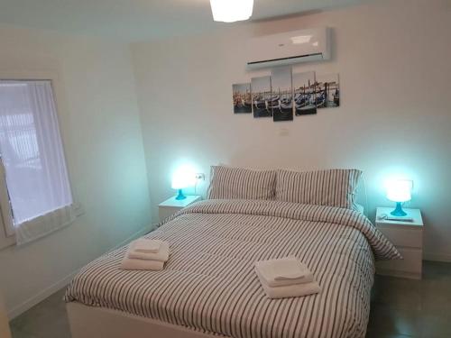 ein Schlafzimmer mit einem Bett, auf dem zwei Handtücher liegen in der Unterkunft center Mestre 15 minutes from Venice, parking Bellini in Mestre