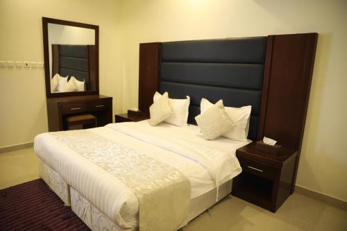 Quiet Rooms Suites 6 By Quiet Rooms في الرياض: غرفة نوم بسرير كبير ومرآة