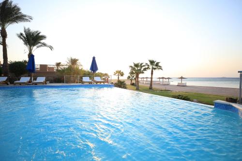 a large swimming pool next to the beach at Shams Prestige Abu Soma (Adults Only) in Hurghada