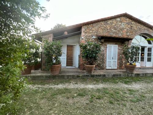 una casa de ladrillo con macetas delante de ella en Agriturismo Baratti en Baratti