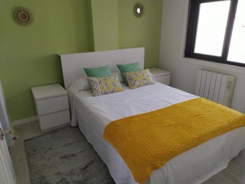 a bedroom with a bed with a yellow blanket on it at Rua GALICIA in A Guarda