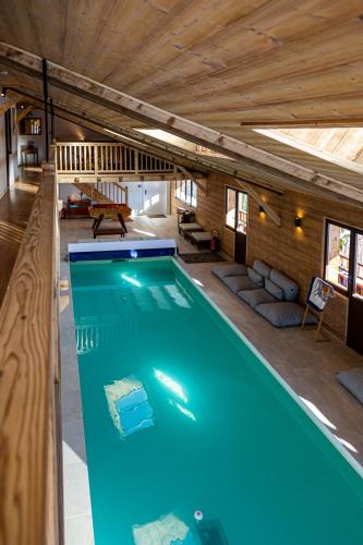 une piscine au milieu d'une maison dans l'établissement Grand chalet convivial avec sa piscine intérieure, à Serraval