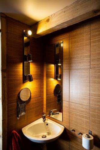 une salle de bain avec un lavabo et un miroir dans l'établissement Grand chalet convivial avec sa piscine intérieure, à Serraval