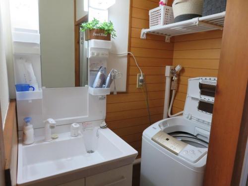 uma pequena casa de banho com uma máquina de lavar roupa e um lavatório em Lu Blue Sado SAWANE - Vacation STAY 12885 em Sado