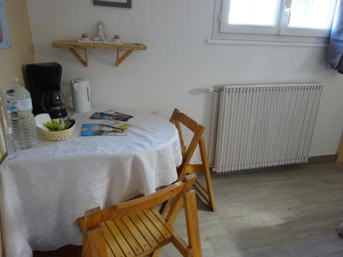 een tafel met een witte tafeldoek en een stoel bij Chez Axeline in Châtillon-sur-Cher