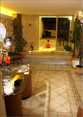a woman is sitting in the doorway of a living room at Hotel Kostis in Skiathos Town