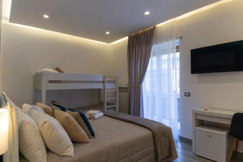 a bedroom with a bed with pillows and a television at B&B Maremy... I 4 Elementi in Naples