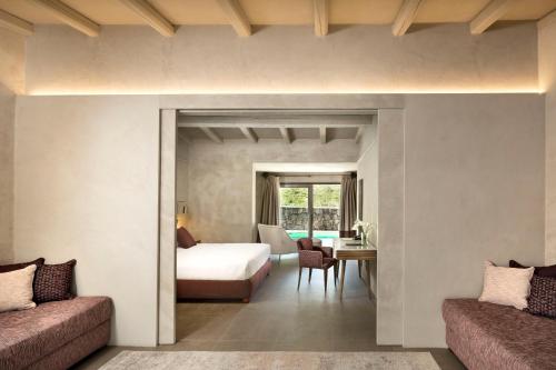 a bedroom with a bed and a room with a desk at Stazzo Lu Ciaccaru in Arzachena